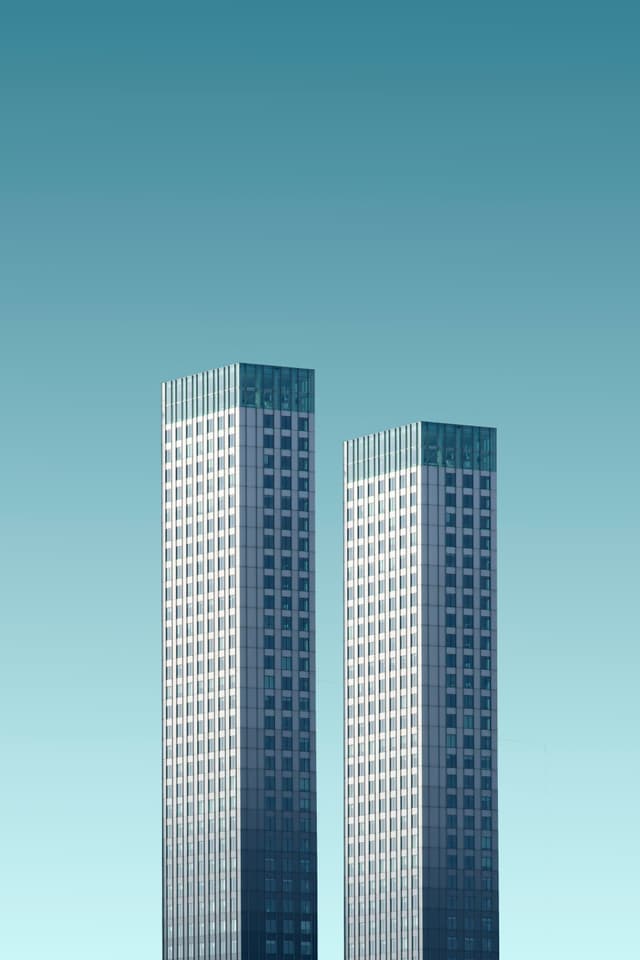 Twin commercial towers against teal sky